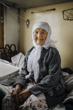 Reyma (82) sits on her bunk in a sleeper carriage.   'Until eleven years ago, we spent our entire lives in Afghanistan. As oralmans (indigenous Kazakhs) we were a thorn in the side of the Soviet sta...