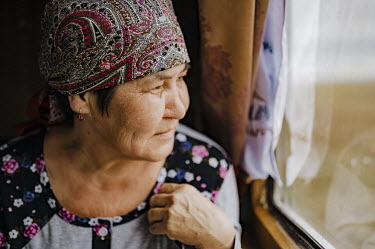Mayra (52) looks out of her carriage window on a long distance train.   'I know everything about the European lifestyle. And also I know that we are completely different. I am going to Karaganda to...