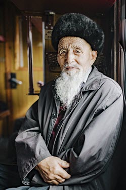 Adylet (83) in winter clothing poses for a portrait in a train carriage.  'Anyone who still mourns the Soviet Union today is a complete idiot! At that time there was no freedom whatsoever, society w...