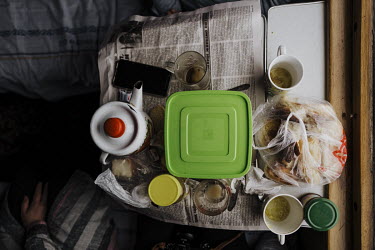 A folding table covered in food and drink in a train carriage.   Food plays an important social role in Kazakhstan. In the train compartment, food is shared between passengers, as a sign of respect...