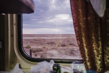 A view out of a train carriage window to the dry Kazakh steppe.