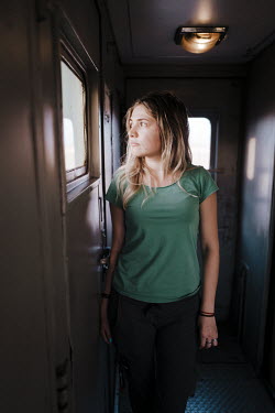 A young woman stands in a train carriage.  Dasha is 30 and is originally from Russia. She has lived in Kazakhstan all her life and works in mining. Although she considers Kazakhstan her home, she fa...
