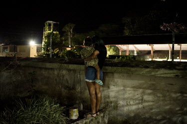 Karla (17, not her real name) and her two year old daughter look over the wall of the shelter for women who have been subjected to domestic violence where they live.   Lago Agrio is a border city betw...
