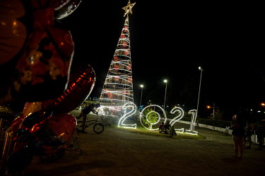 Tourists walk around the central park of Lago Agrio enjoying the Christmas activities on an evening before Christmas.  Lago Agrio is a border city between Ecuador and Colombia and has one of the highe...