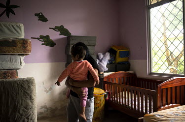 Karla (not her real name), a 17 year old woman, walks her two year old daughter through the shelter for women who have been victims of domestic abuse where they are living. She has been at the shelter...