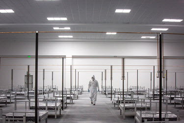 A worker walks through a temporary Covid Attention Centre, dressed in Personal Protective Equipment (PPE).
