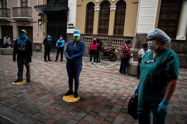 People wait, socially distanced, in front of a pharmacy in Quito.