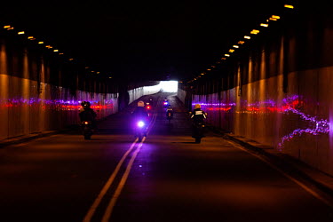 Police riders drive along an empty road in Quito which has been shut down with a curfew due to the coronavirus pandemic.