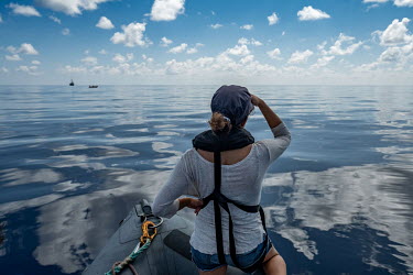Deckhand Laia Pascual looks out for signs of sperm whales in the Indian ocean near the Seychelles.