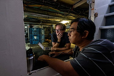 Radio operator Noom Srithanomwong and ROV operator John Murphy install a new server in the pygmy deck of the Greenpeace vessel Arctic Sunrise.