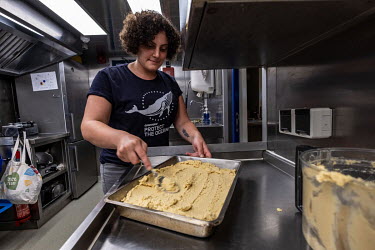 Assistant cook and video producer Elham Haidar prepares a batch of hummus in the galley of the Greenpeace vessel Arctic Sunrise.