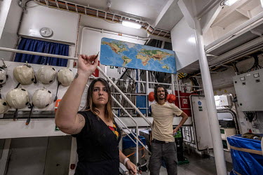 Juliana Costa and Dan Jones play darts after work on the Greenpeace vessel Arctic Sunrise.