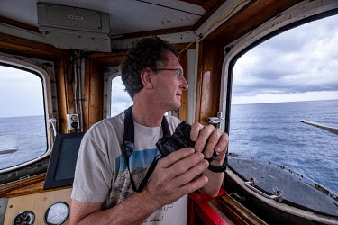 Marine scientist Tim Lewis looks out from the crow's nest of the Greenpeace vessel Arctic Sunrise during a sightings survey on the Saya de Malha Bank in the Indian Ocean.