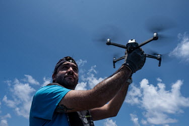Third mate Mariano Rauleti cacthes a drone as a Greenpeace team documents sperm whales near the Seychelles.