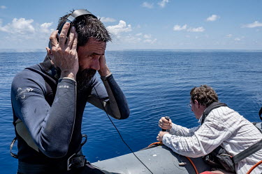 Deckhand Alessandro Montanari listens to sperm whales through a hydrophone near the Seychelles.