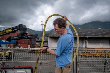 Marine scientist Tim Lewis makes minor repairs to a hydrophone in the port of Victoria, Seychelles, ahead of a ship tour on the Greenpeace vessel Arctic Sunrise in the Indian Ocean.