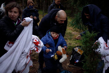 Syrian family getting help from volunteers and paramedics. They were wandering between borders for many days, pushed across the borders by the border guards.   Thousands of migrants attempted to cross...