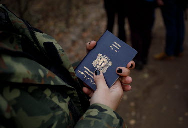Border guard holding Syrian passports.   Thousands of migrants attempted to cross into Europe along the Poland Belarus border in the autumn of 2021. By the last week of October six migrants had died s...