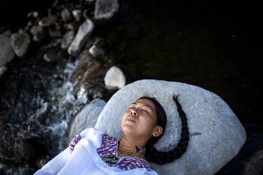Lourdes Molina, a 27 year old Karanki indigenous woman, relaxes on a rock above the Rinconada river, her favorite place where she goes in the afternoons to breathe and sing.