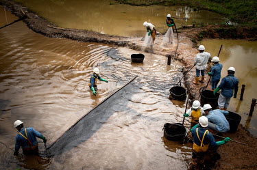 Staff from Petroamazonas, an Ecuadorian oil company, clean the waste pool located at the Secoya 16 Field. The workers are people from the surrounding communities who work full days in direct contact w...