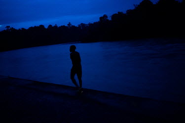 A man comes out of the water after taking a bath in the Santiago river. Playa de Oro is an a community of people descended from African slaves located on the Ecuador Colombia border. Its territory is...