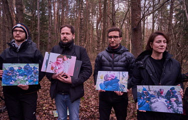 Polish volunteers holding pictures of migrants during a press conference organised by Grupa Granica (Border Group) in the forest near a restricted area not far from Kuznica. Volunteers of Grupa Granic...