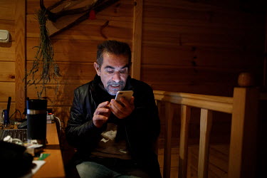 Iraqi activist Aras Palak at his office in a rented house near the state of emergency zone by the Belarussian border. He is trying to help a migrant stuck in the forest. Hundreds of migrants, mainly f...