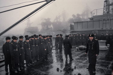 Russian marines stand on deck of their ship as a heavy fog hangs over Vladivostok harbour and the deck of a Russian warship.