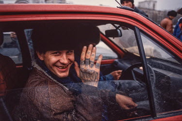 A car dealer on the harbour front in Vladivostok. The tattoos on his hands signify that he's been to prison.  After the end of the Soviet era Vladivostok entrepreneurs saw used Japanese cars as a big...