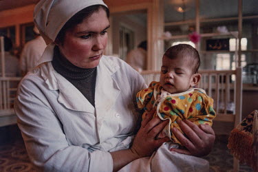 A nurse holds a baby with birth defects. She was born blind and with no arms, possibly related to the 1986 Chernobyl nuclear meltdown that released radiation across Ukraine and neighboring Belarus. Th...