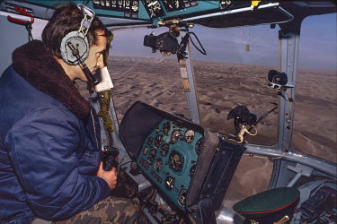 A Soviet border forces pilot flies a helicopter along the Turkmenistan / Afghanistan border. Russian control of this border was about to disappear with the break up of the Soviet Union and independenc...