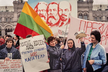 Grieving mothers hold photos of their sons who died in, or never returned from, Afghanistan. They are standing on Red Square directly in front of Gorbachev and other party leaders who are looking down...
