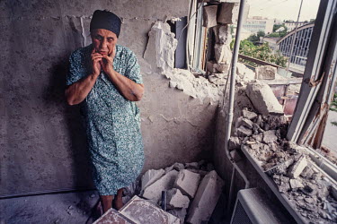 A woman stands near the window of her apartment that has been hit by an artillery shell in Tirasopol.   Moldova gained its independence, along with all the other former Soviet Republics following th...