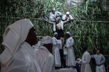 During Holy Week, an annual celebration of the descent of Christ, men in white robes take the crucifix down from the main altar in the church in El Juncal and carry it around the town's streets while...