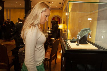 A woman looks at diamond jewelry on display at the opening of a new de Grisogono designer jewelry store.