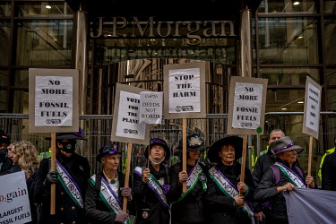 Climate activists dressed up as suffragettes gather outside the JP Morgan offices in Glasgow with placards to protest investment in fossil fuels.