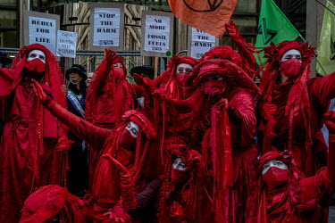 Climate activists in bright red costumes gather outside the JP Morgan offices in Glasgow to protest investment in fossil fuels.