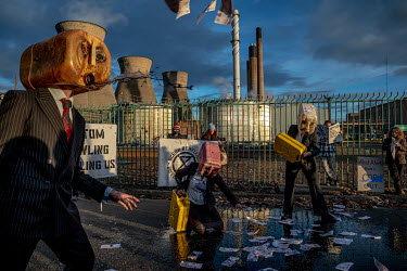 Members of Ocean Rebellion protest outside Grangemouth Oil Refinery. Oil Head Performers vomited fake oil to protest the fact that so many jobs in Scotland are reliant on fossil fuels.