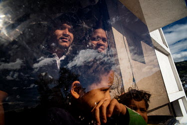 The Salazar Mujica family looks out the window of their house. They arrived in Ecuador in 2019 on foot from Venezuela. Luisa and Robert, the parents, have lost their jobs since the pandemic started. T...