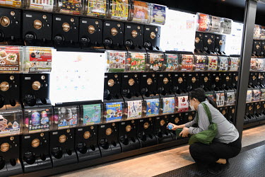 A woman buys a capsule toy, or gachapon, at Akihabara Station in Tokyo. Over 150 gachapon capsule vending machines are installed here.