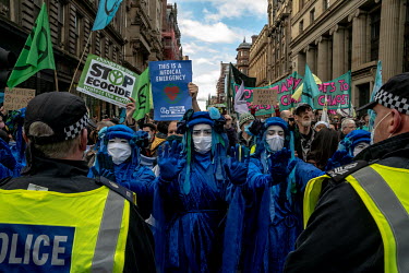 Climate activists in blue costumes face a line of police during a â��Greenwash' march through central Glasgow. Police closed roads and encircled the activists, causing groups to break away and start...