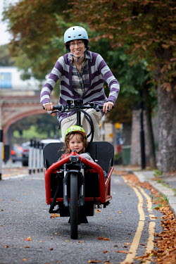 A mum with child in a cargobike on a segregated cycle lane in South London.