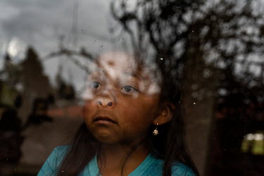 Sayana Cuasque, 6, playing with the window at her home. Sayana returned to the rural community of San Clemente because her parents lost their jobs during the COVID 19 pandemic, and she and her brother...