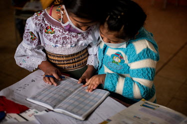 Two Karanki indigenous girls are studying together during their classes in the San Clemente school.