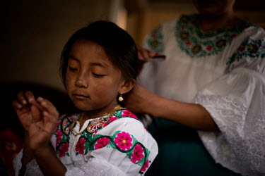 Sayana Cuasque, 6, is combing her hair before going to school. Her mum is helping her to get ready for her classes. School uniform is the traditional Karanki dress that includes a handmade embroidery...