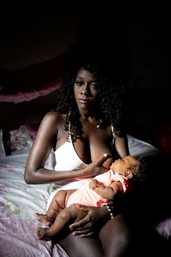 Maria Teresa Caicedo, 23, poses for a portrait at her home while feeding her daughter Noa, 3 months. She is one of the three community teachers at Playa de Oro school.  Maria is in the last year of h...
