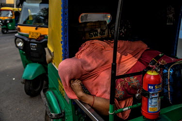 A woman with Covid 19 waits outside in an auto rickshaw for a bed to become avalilable at the LNJP hospital in Delhi.
