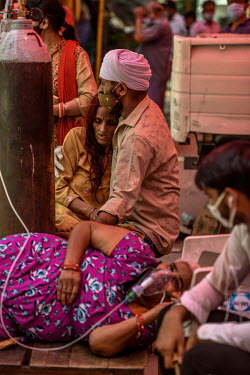A young Sikh man hugs an older female relative with breathing problems as a result of contracting Covid 19, as people around then receive free oxygen support at a gurdwara, a place of assembly and wor...