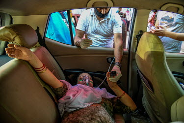 An older woman with breathing problems as a result of contracting Covid 19 receives free oxygen support in a car, provided by a gurdwara, a place of assembly and worship for Sikhs, amidst the spread o...