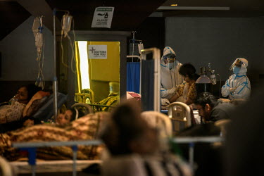 Health workers in personal protective equipment care for patients in a temporary medical facility set up during the Covid 19 pandemic in Delhi.